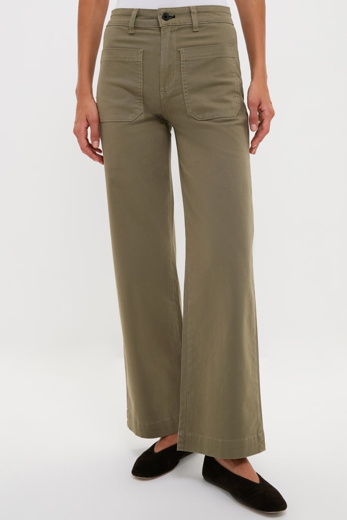 Person wearing classic Olive Sailor Pant, high-waisted with wide-leg design and patch pockets, paired with black flats, embodying effortless, high-end style.