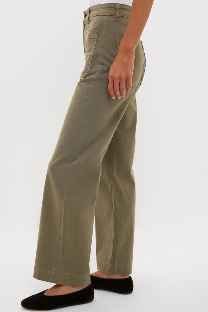 Model wearing classic Olive Sailor Pant, high-waisted with wide-leg and patch pockets, styled with black flats. Effortless, fun, and high-end design.