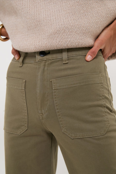 Classic Olive Sailor Pant with large patch pockets and wide-leg design, styled effortlessly with a chunky sweater and gold bangle for a high-end, fun look.