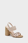 A beige open-toe sandal by Larroude, featuring a block heel, wide ankle strap, and studded front straps, crafted in collaboration with Chloe Gosselin and shown on a white background.