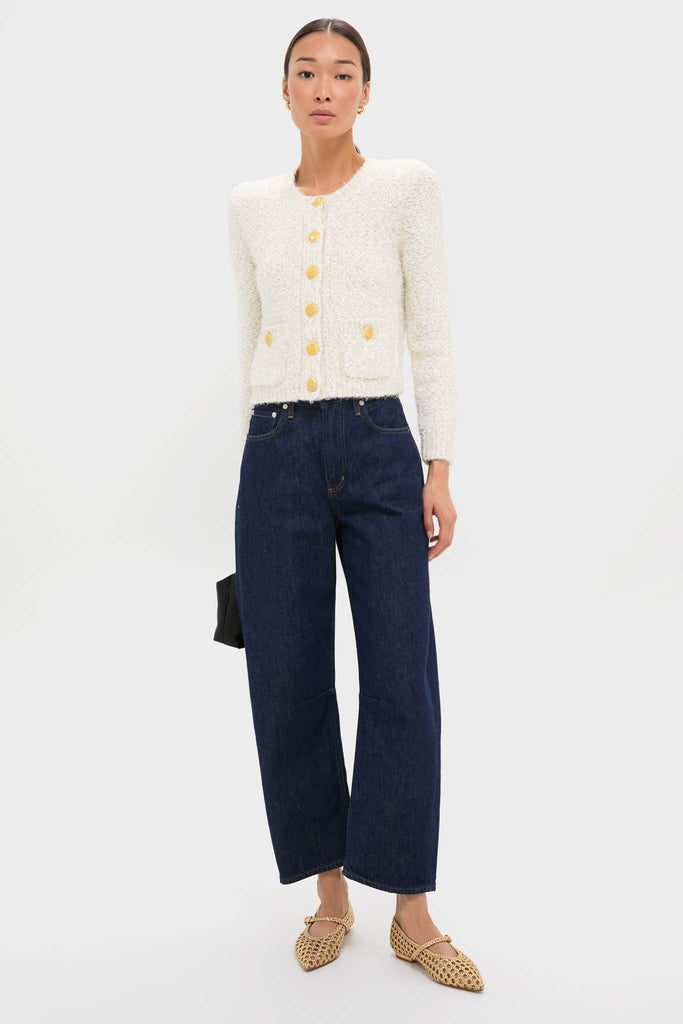 Model showcases classic Gold Gracie Pointed Toe Crochet Flats, featuring elegant woven vegan leather and adjustable strap, styled with high-waisted jeans and a chic cardigan.