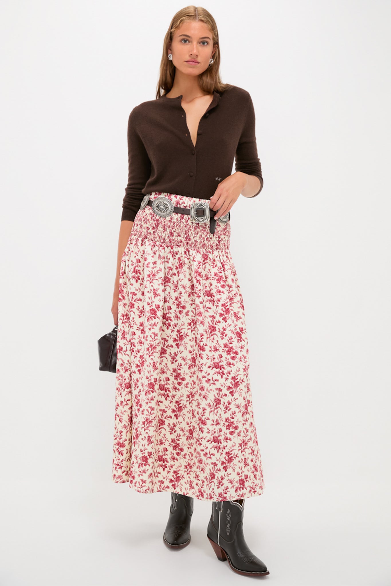 Woman in fitted cardigan and floral skirt, showcasing Chocolate and White Low Bright Boots—classic black leather cowboy boots with subtle Western detailing, embodying effortless high-end style and fun vintage vibes.