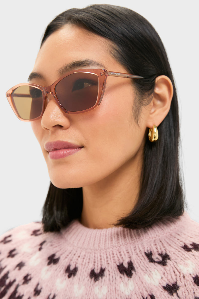 Woman in profile wearing classic, high-end Shiny Transparent Amber Brown Lettering Logo Thin Sunglasses, exuding effortless cool with cat-eye frames and subtle Saint Laurent branding.