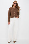 Model in a classic Brown Morgan Cardigan with gold crystal buttons, paired with high-waisted white jeans and dark tortoiseshell heels, exuding effortless high-end style.