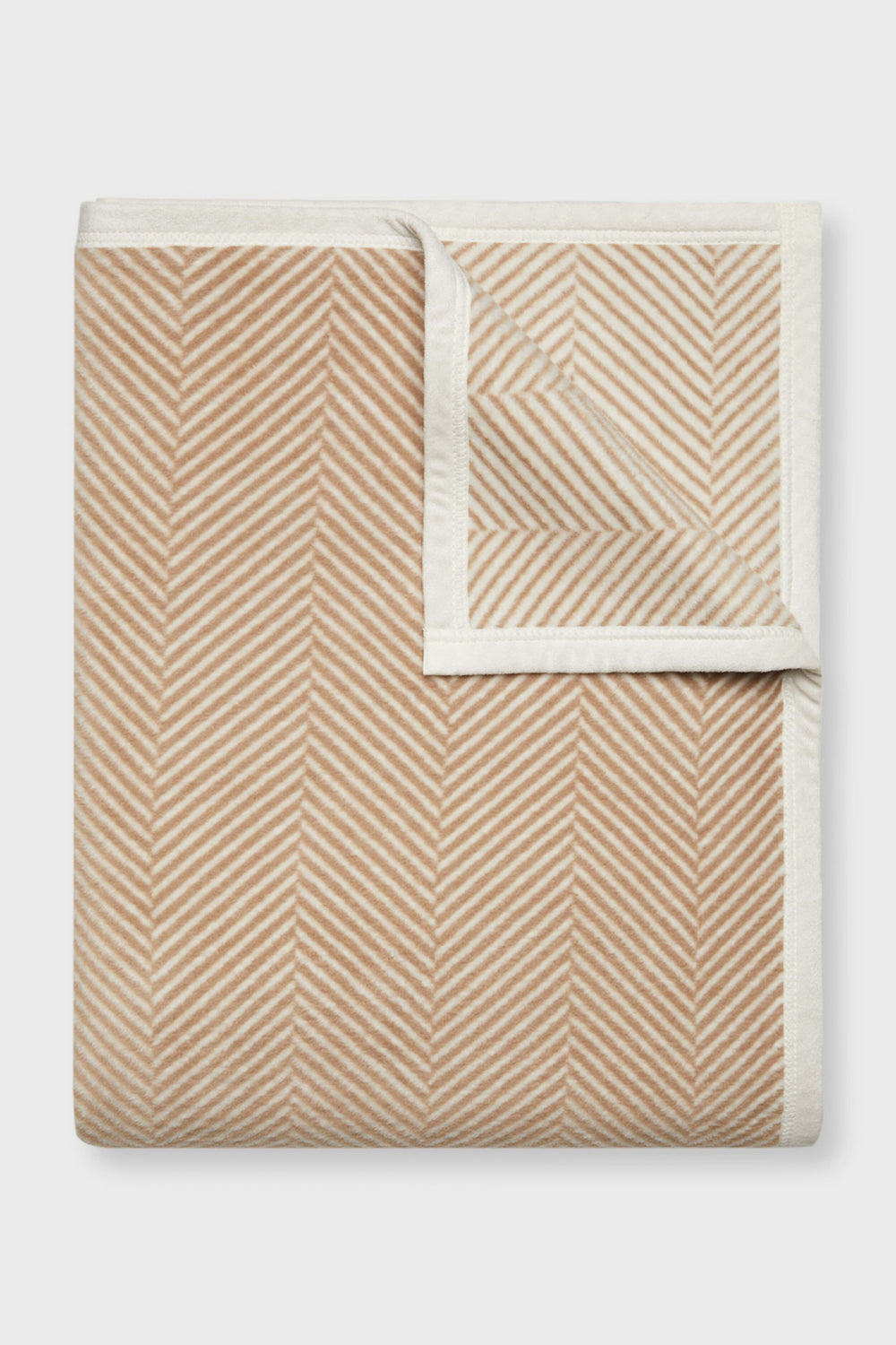 ChappyWrap beige and white herringbone blanket with chevron stripes and a contrasting border, displayed from above.
