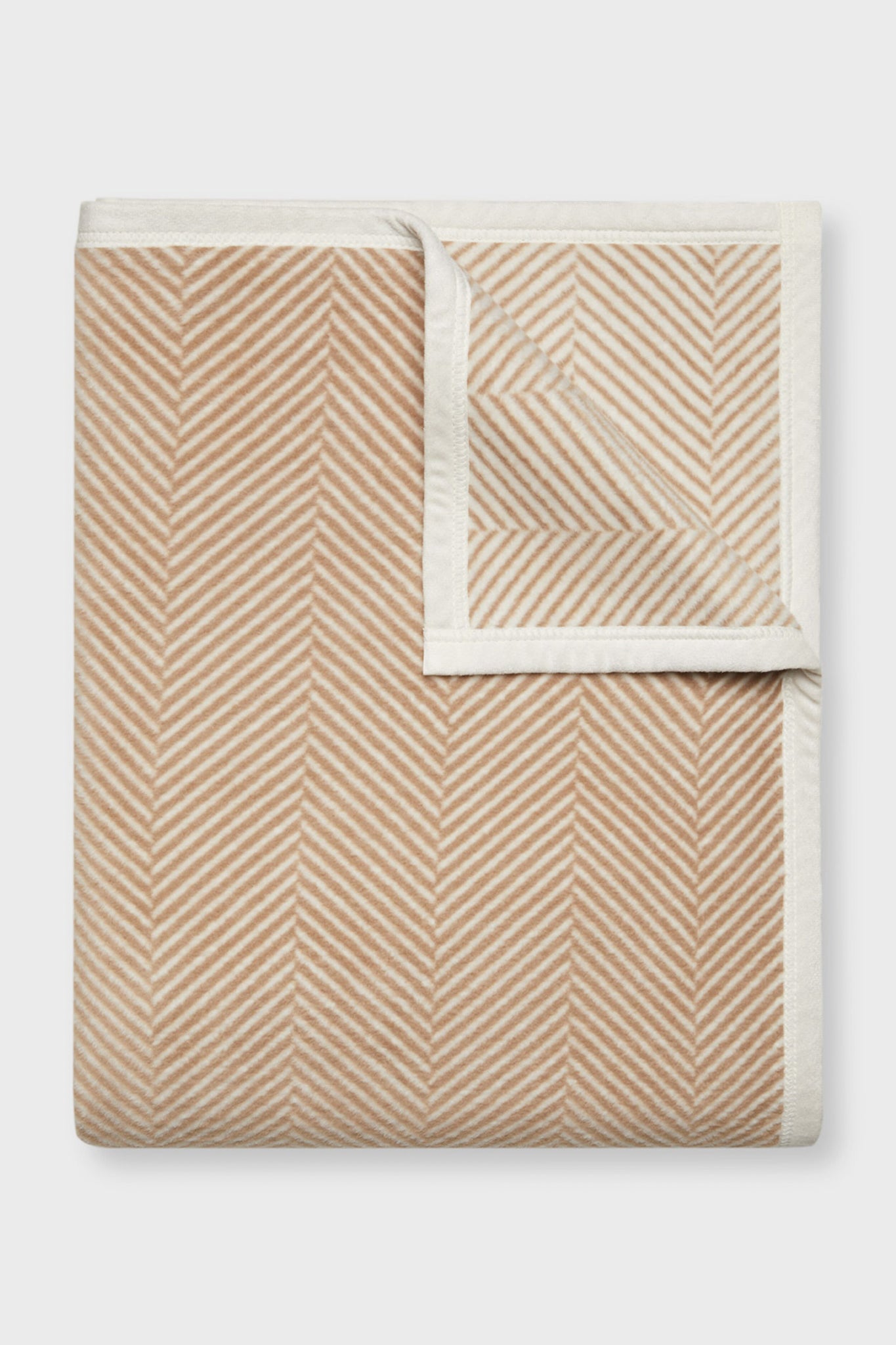 ChappyWrap beige and white herringbone blanket with chevron stripes and a contrasting border, displayed from above.