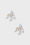 A pair of statement earrings from Tuckernuck Jewelry, in white with elegant gold-plated accents.