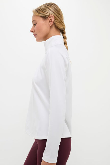 Woman modeling the classic White Performance Jersey Carver Quarter Zip Tee, featuring a stand collar and quarter zip, ideal for an effortless, high-end activewear look.