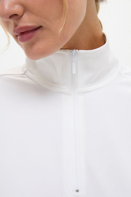 Person wearing the classic White Performance Jersey Carver Quarter Zip Tee with a high collar and front zip, showcasing an effortless, high-end look perfect for active and leisure pursuits.