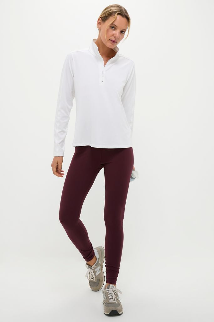 Athletic woman in White Performance Jersey Carver Quarter Zip Tee with stand collar and quarter zip, embodying classic, effortless style for high-end activewear.