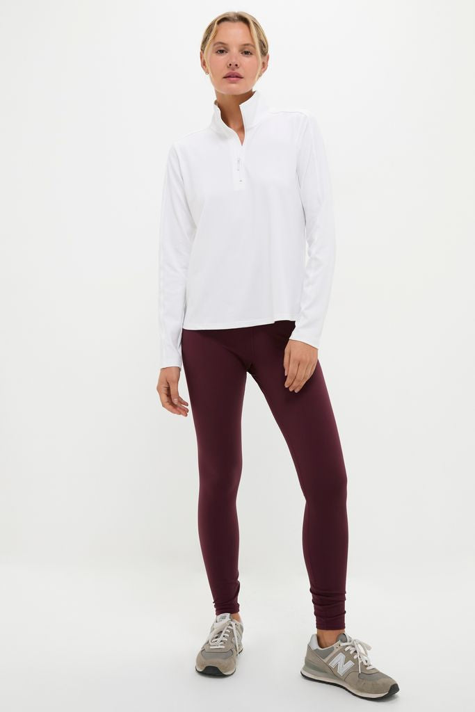 Woman models the classic, high-end White Performance Jersey Carver Quarter Zip Tee, perfect for an effortless, fun look at pilates or while traveling.