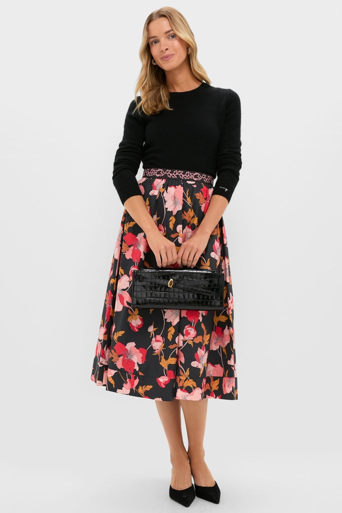 Woman wearing Black & Shades of Pink Floral Embroidered Sia Maxi Skirt with black sweater and pumps, holding a high-end black croc-embossed handbag for an effortless, classic look.