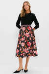 Woman in a classic, effortless Black & Shades of Pink Floral Embroidered Sia Maxi Skirt, styled with a fitted sweater and kitten heels, embodying fun, high-end elegance.