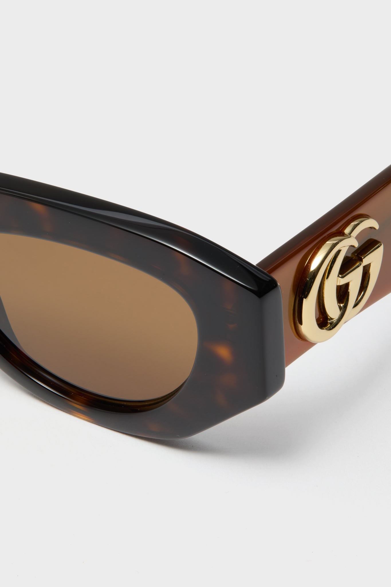 Shiny Dark Havana Cat-Eye Gucci Generation Sunglasses, showcasing classic tortoiseshell frames, brown-tinted lenses, and an effortless gold GG logo for a high-end, fun look.