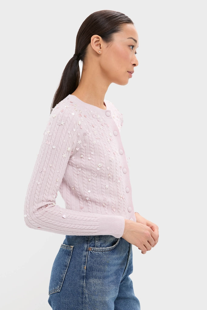 Woman in profile wearing a Blush Pink Gilberte Embroidered Cardigan, a classic, effortless piece with subtle sequins, styled with medium-wash blue jeans.