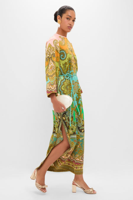 Model in a classic, paisley print dress, accessorized with Shell and Pom Elaine Earrings, effortlessly styled with a pearlescent clutch and high-end sandals.