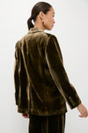 Woman in an Olive Velvet Diana Blazer, showcasing a classic, high-end style with effortless elegance, accessorized with drop earrings, embodying Tuckernuck's fun and confident fashion ethos.