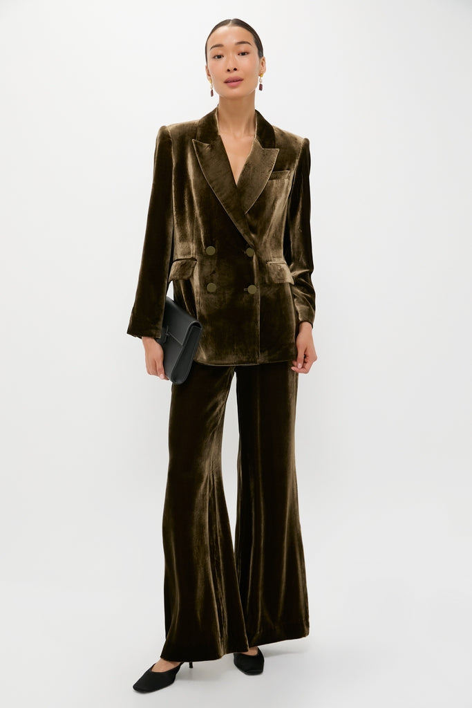Model in a classic, high-end Olive Velvet Diana Blazer, paired with matching trousers, black clutch, and heels for an effortless, fun, and confident look.