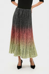 Model wearing the Ombre Sequin Bleeker Maxi Skirt, a classic, high-end pleated skirt with a metallic-sequin ombré fade, styled effortlessly with black heels and top.
