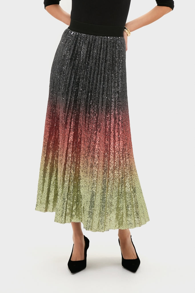 Model wearing the Ombre Sequin Bleeker Maxi Skirt, a classic, high-end pleated skirt with a metallic-sequin ombré fade, styled effortlessly with black heels and top.