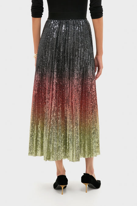 Woman wearing the Ombre Sequin Bleeker Maxi Skirt, a high-waisted, pleated design with an effortless ombré sequin gradient, paired with classic black velvet pumps.