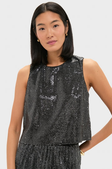 Person wearing classic Charcoal Sequin Bowery Top, exuding effortless elegance with black sequins, styled with small gold hoop earrings for a fun, high-end look.