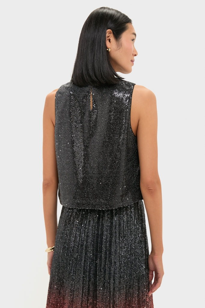 Woman in a classic, sleeveless Charcoal Sequin Bowery Top with keyhole detail, paired with an effortlessly chic pleated skirt, embodying high-end, fun sophistication.