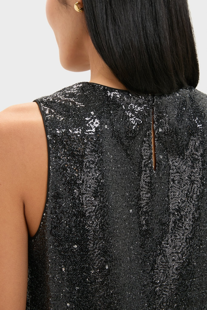 Person wearing the Charcoal Sequin Bowery Top, a classic and high-end sleeveless piece with an effortless sparkle, featuring a key-hole back and gold hoop earring.