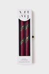 Holiday Hand Painted Taper Candles (Set of 2) in a classic white box, featuring deep burgundy wax with elegant green and gold garland motifs, effortlessly high-end.