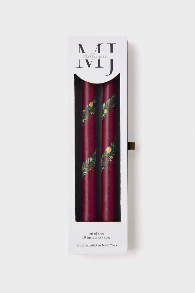 Holiday Hand Painted Taper Candles (Set of 2) in a classic white box, featuring deep burgundy wax with elegant green and gold garland motifs, effortlessly high-end.