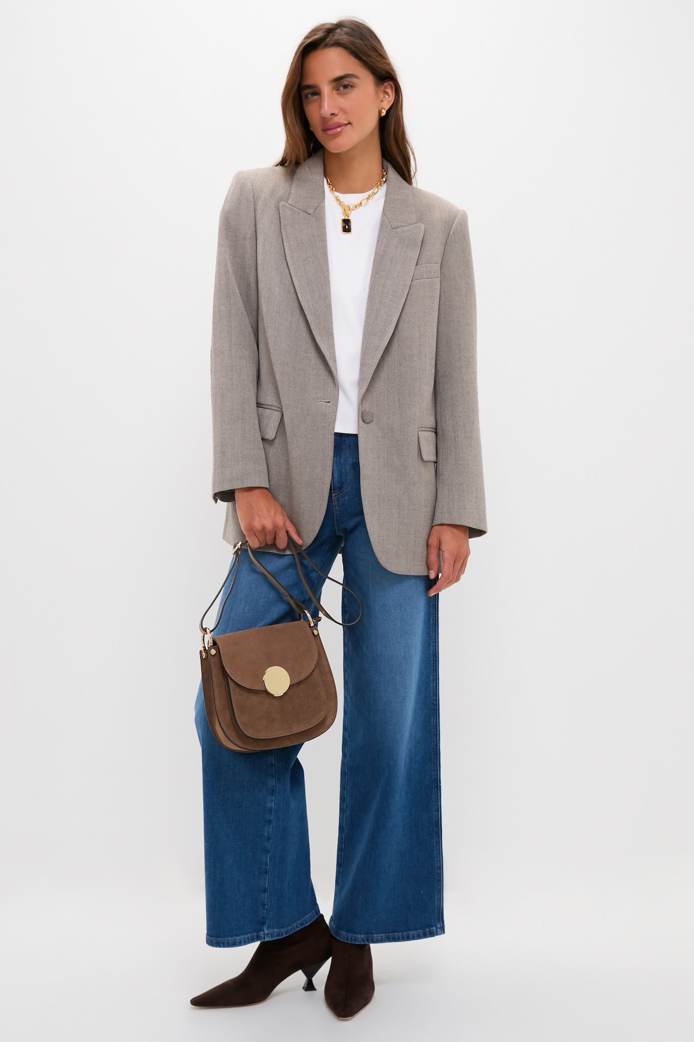 Woman in a smart-casual outfit showcasing the Taupe Agave Shoulder Bag, a classic, effortless, high-end accessory, adding texture with gold accents and suede material.