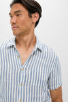Man wearing classic Ivory Stripe Short Sleeve Palma Linen Shirt with vertical stripes; features include a front button placket and chest pocket for an effortless, high-end summer style.