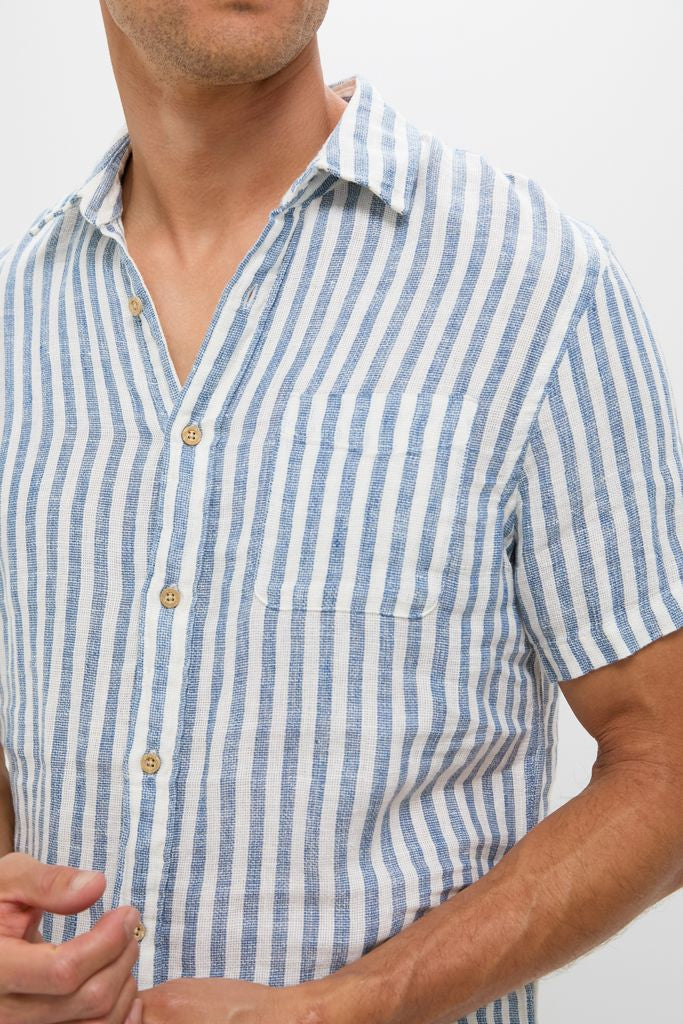 Ivory Stripe Short Sleeve Palma Linen Shirt showcases classic, effortless style with vertical stripes, wooden-tone buttons, and a chest pocket, embodying high-end, fun summer fashion.
