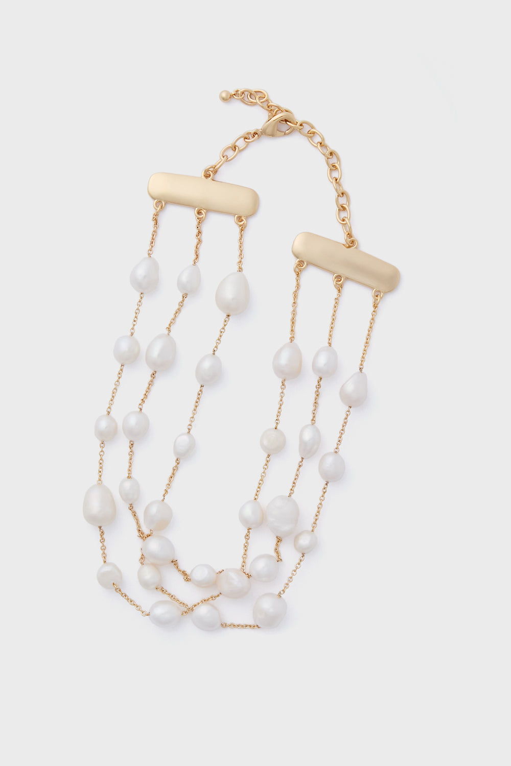 The Cult Gaia Nyala Choker is a gold chain necklace with three strands of irregular freshwater pearls and rectangular gold bars, finished with an adjustable clasp. Discover unique accessories that elevate any look.