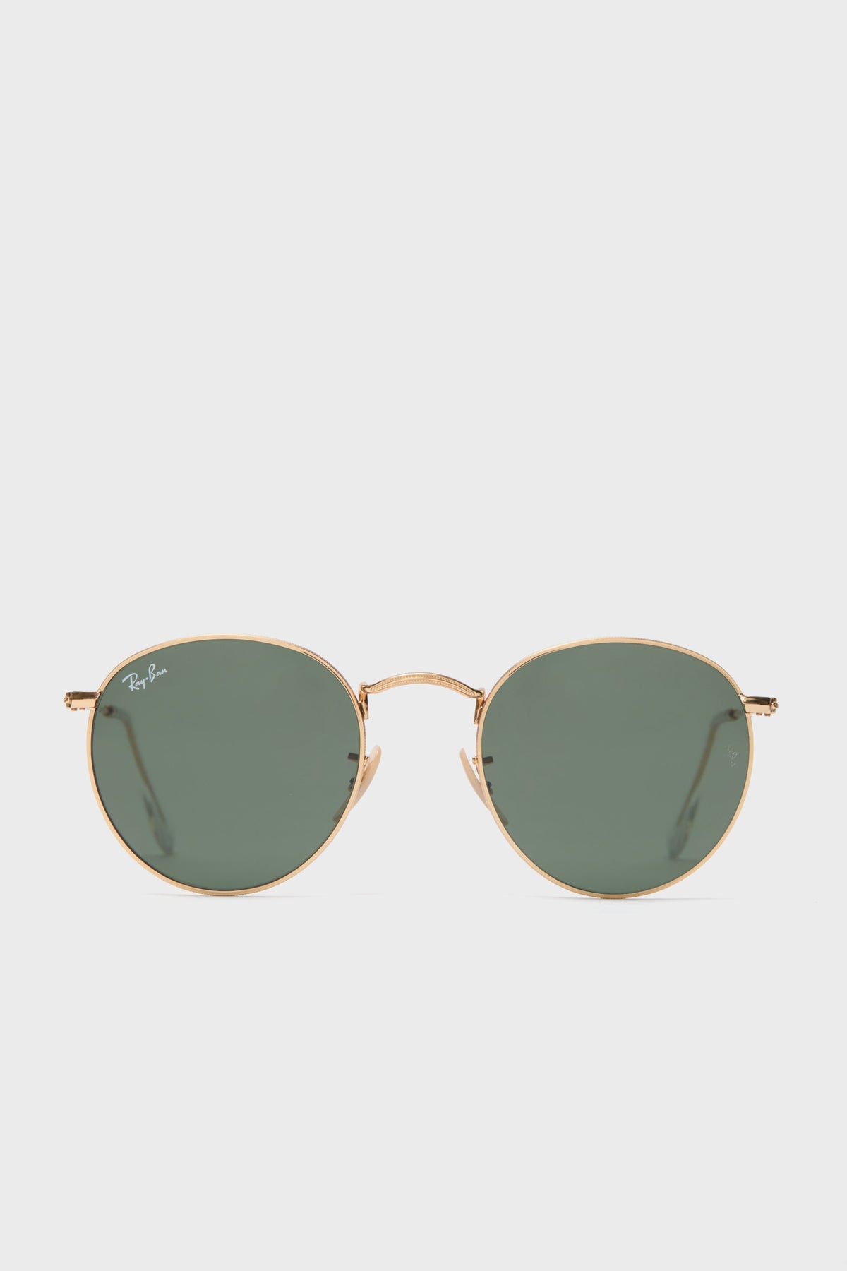 A pair of Ray-Ban round sunglasses with a gold frame and green-tinted lenses is displayed.