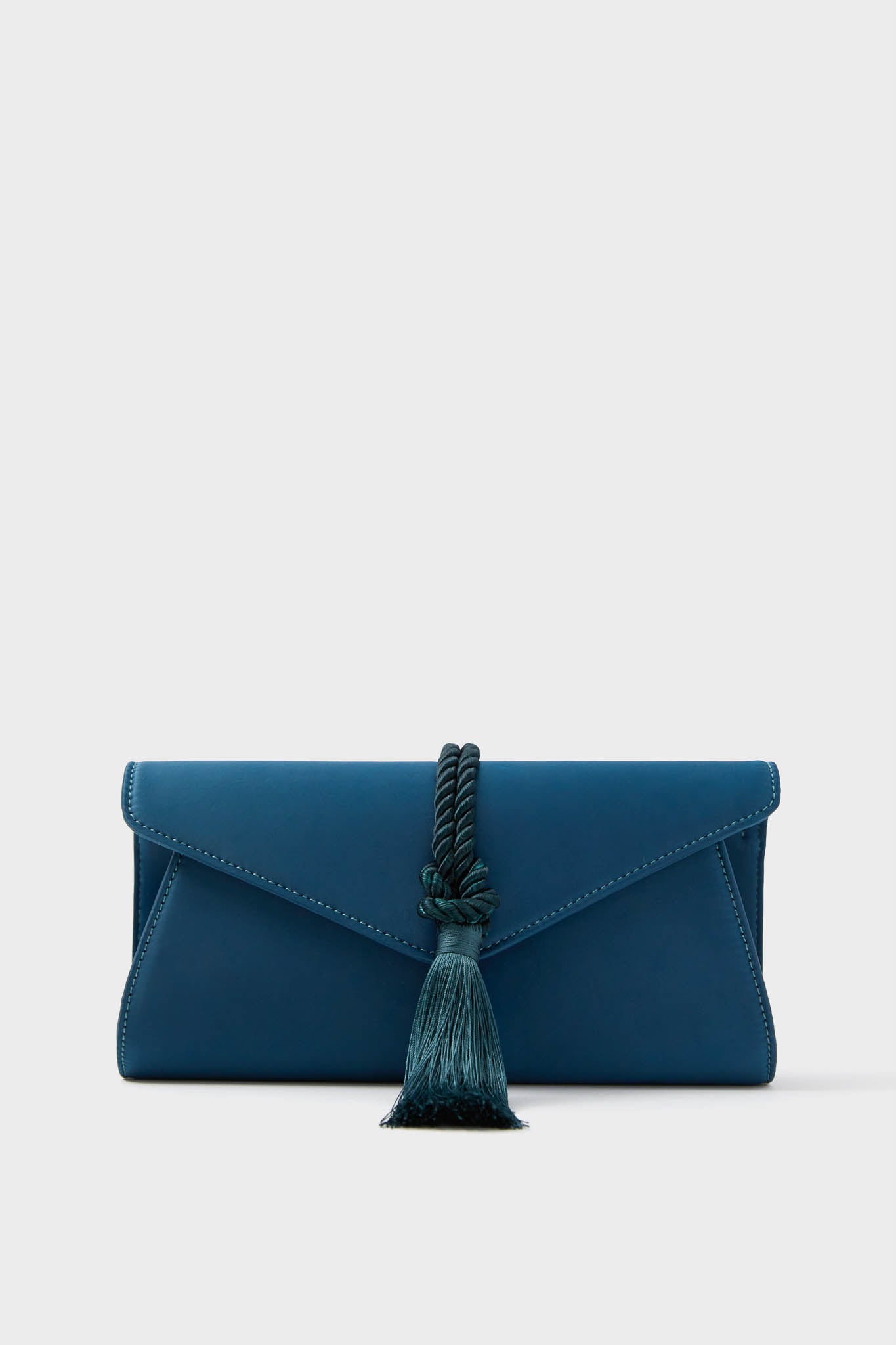 A blue envelope-style party clutch with a tassel and rope detail on the front, the Tuckernuck Accessories Satin Gabrielle Clutch is an elegant choice for special events.