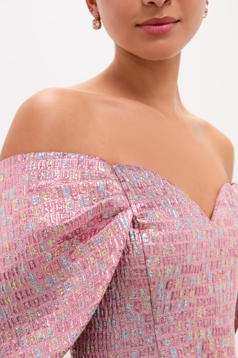 Woman wearing the Pink Multi Jacquard Off-the-Shoulder Kara Midi Dress, featuring classic puff sleeves and a gentle sweetheart neckline, paired with small drop earrings for an effortless, high-end look.