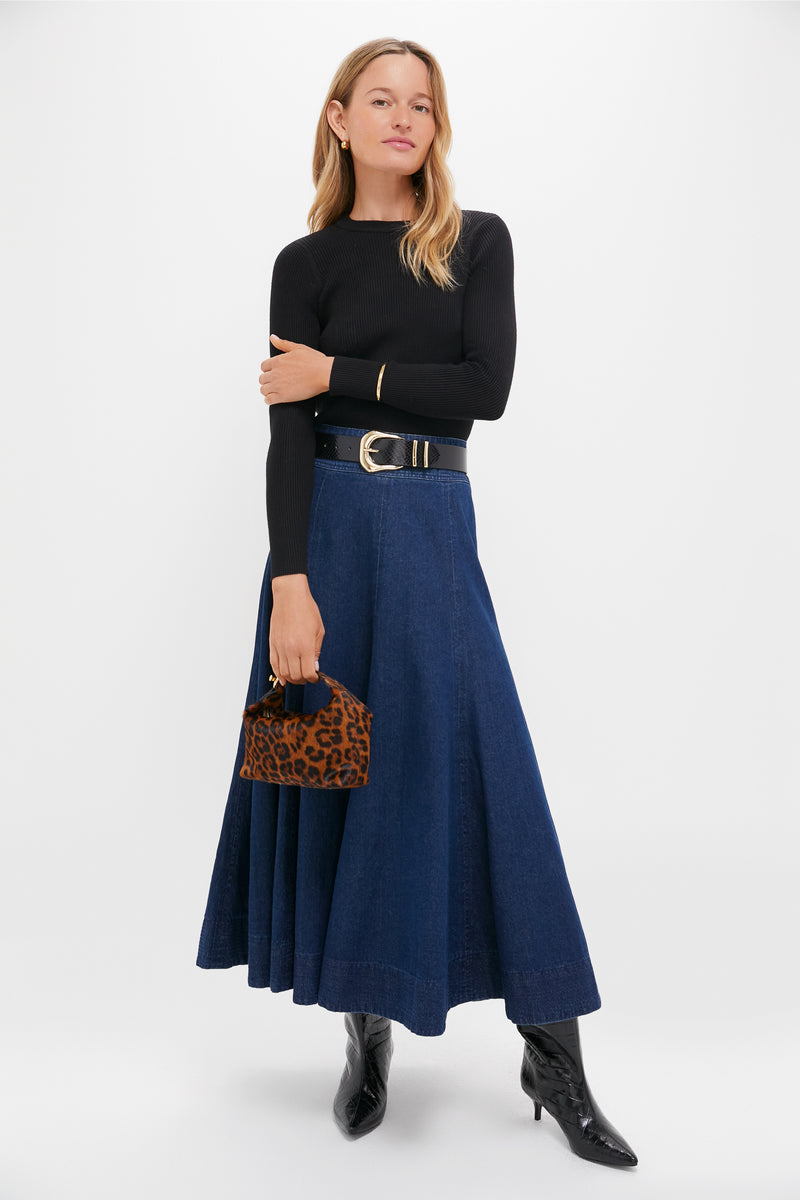 Woman in classic Black Maryana Up Mid Boots with croc-embossed texture, styled effortlessly with a denim skirt, black top, and leopard-print bag for a high-end, fun look.