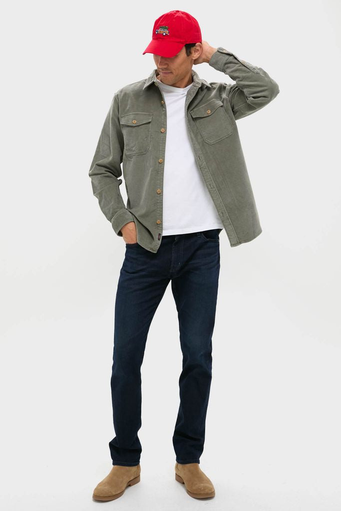 Man wearing Exclusive Needlepoint Christmas Dad Wagon Hat, featuring a hand-stitched car and tree, effortlessly paired with an olive shacket, embodying classic, high-end, and fun style.