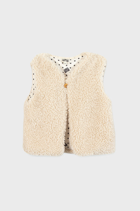 A sleeveless, cream-colored teddy vest by Bonton with a single front button and white lining adorned with small black stars—an ideal way to add Parisian chic to children’s outfits.