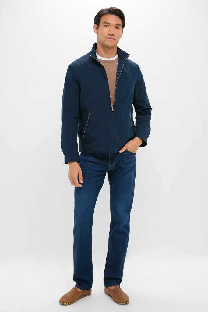 Man models The Graduate in Crusade Wash Denim, showcasing classic, effortless style with a navy jacket, tan top, and brown slip-on shoes, embodying Tuckernuck's high-end, fun vibe.