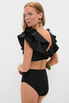 Model wearing Black Mila Two Piece swimsuit with ruffled straps and high-waisted bottoms, exuding a classic, effortless, and high-end style, perfect for a fun day by the water.