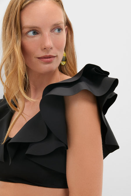 Close-up of a woman wearing the classic Black Mila Two Piece with ruffled straps and hoop earring, embodying effortless, high-end swimwear style.