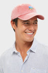 Young man wearing the classic Nantucket Red American Flag Needlepoint Hat, effortlessly styled with a light striped shirt, showcasing its fun, high-end hand-stitched design.