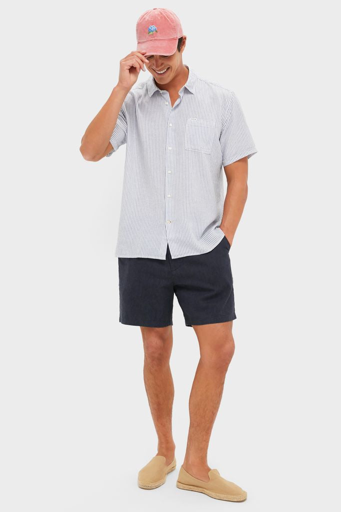 Young man in a Nantucket Red American Flag Needlepoint Hat, adjusting the brim. The classic, high-end cap features hand-stitched details, perfect for an effortless, fun style.