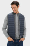 Male model wears the Mid Gray Essential Gilet, a classic and effortless quilted vest with snap-button closure, perfect for layering and cool-weather activities, embodying high-end style and fun.