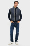 Man models classic, high-end Mid Gray Essential Gilet with quilted front, layered over a sweater, paired with jeans and sneakers for an effortless, fun fall look.