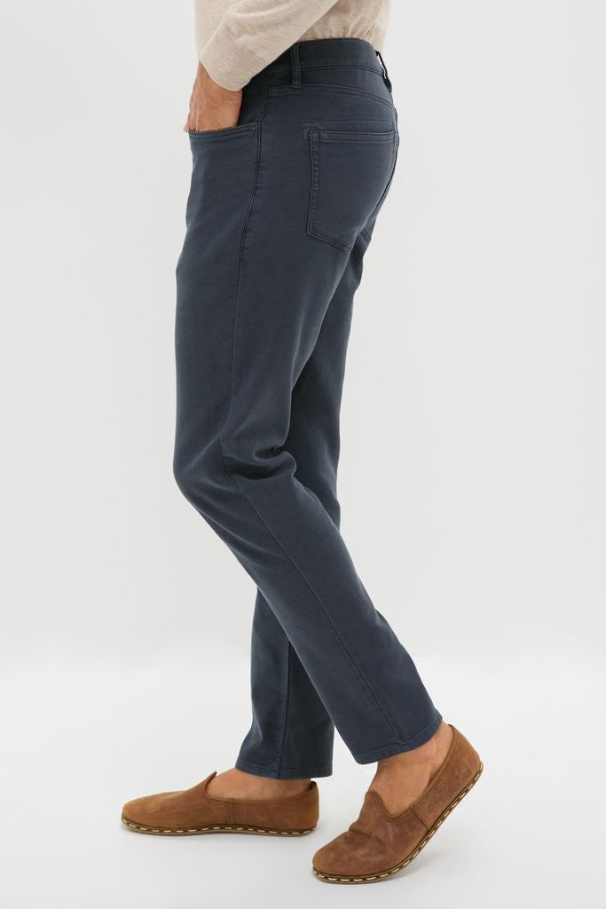 Navy Stretch Terry 5 Pocket trousers: classic, high-end style with effortless fit. Paired with brown suede loafers, embodying fun, adventurous spirit.