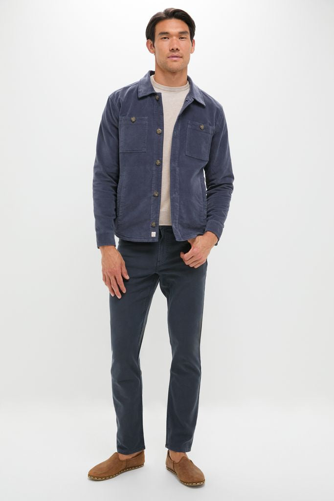Model in classic Navy Stretch Terry 5 Pocket chinos, styled with an effortless navy chore jacket and suede loafers, exuding a high-end, fun, smart-casual vibe.