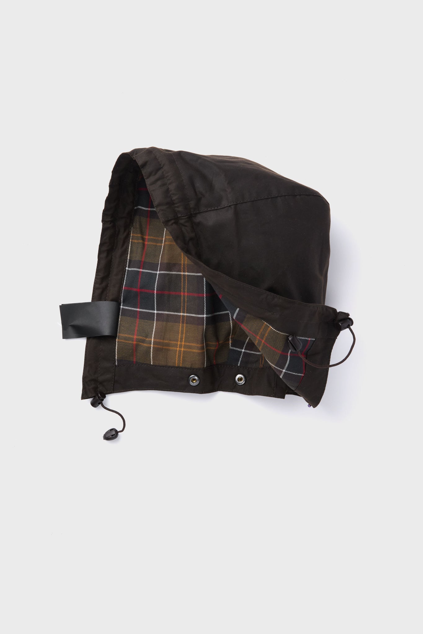 A detachable black Barbour waxed cotton hood with plaid lining, drawstring adjustment, and metal grommets, designed for use with Bedale and Beadnell jackets.